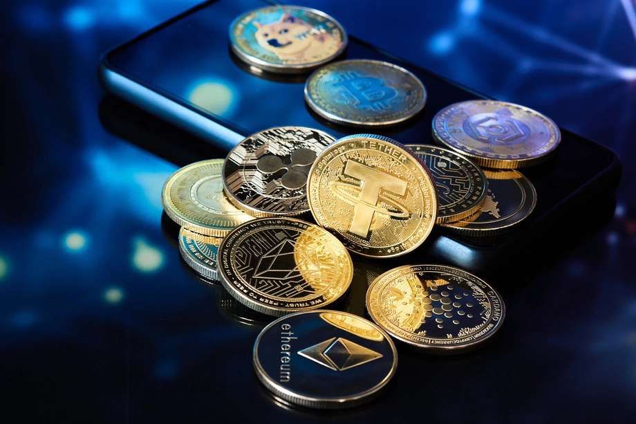 Assorted cryptocurrency coins on a smartphone screen reflecting blue light, symbolizing mobile cryptocurrency trading and investments.