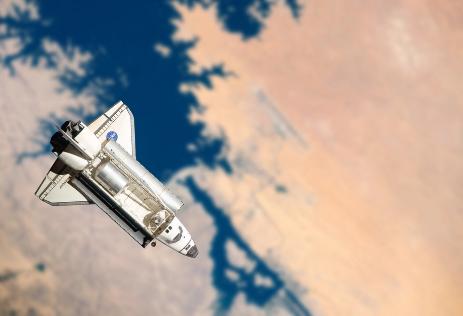 Space shuttle orbiting Earth with a clear view of its wings and payload bay doors open, against a backdrop of the planet's surface.