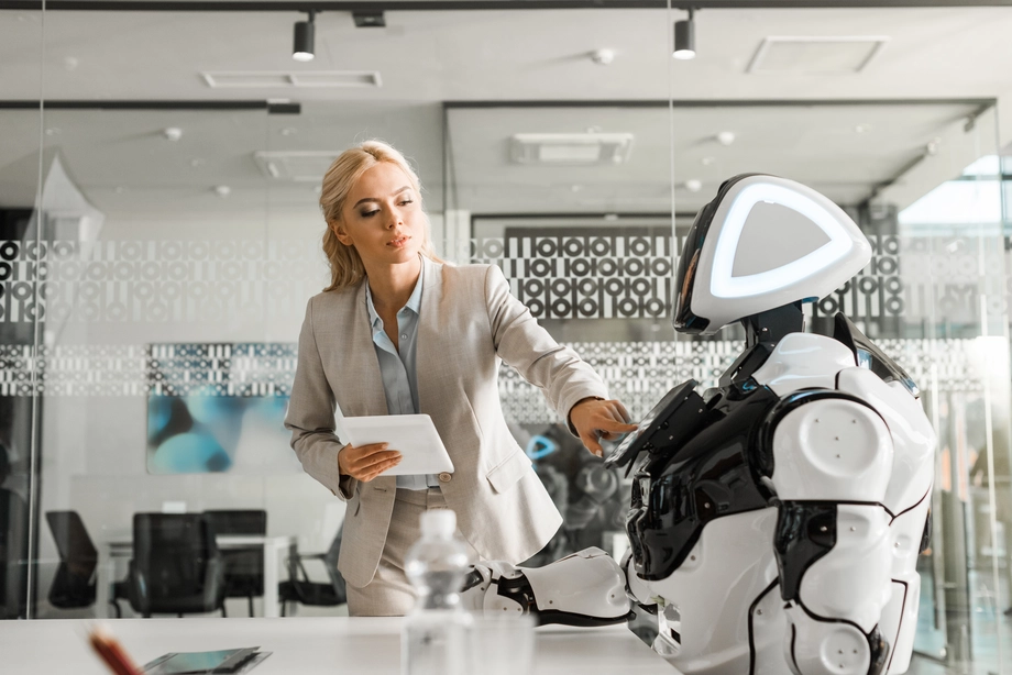 Professional woman interacting with advanced humanoid robot in a high-tech office environment
